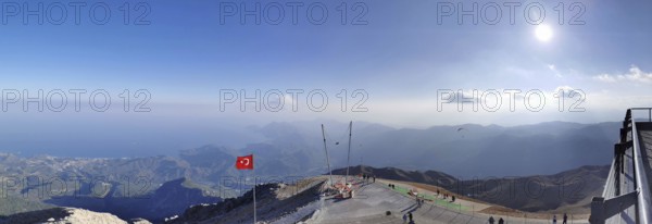 Panorama at the summit of Tahtali Dagi, extensive mountain landscape with a Turkish flag and clear