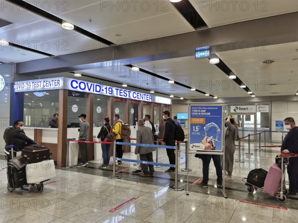 People are standing in a queue in front of a COVID-19 test center at the airport, Antalya, Turkey