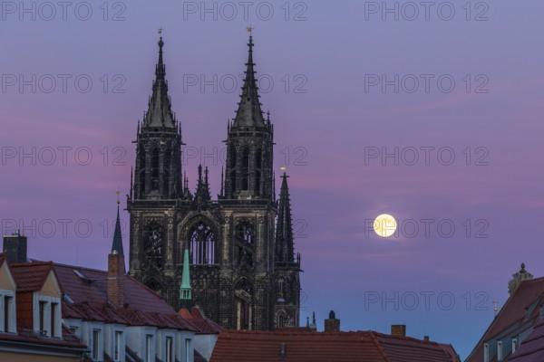 Full moon next to the cathedral towers at blue hour in Meissen, Saxony, Germany