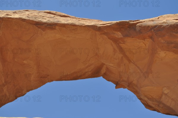 Skyline Arch, a sand-colored rock arch standing out against the blue sky, Arches National Park,