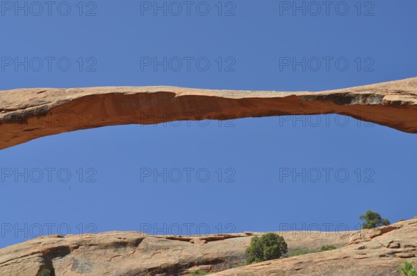 Close-up of a natural stone bridge, called Landscape Arch, against the blue sky, Arches National