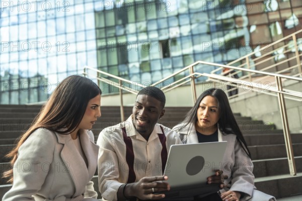 Diverse business professionals or students sitting on urban stairs, discussing project ideas and