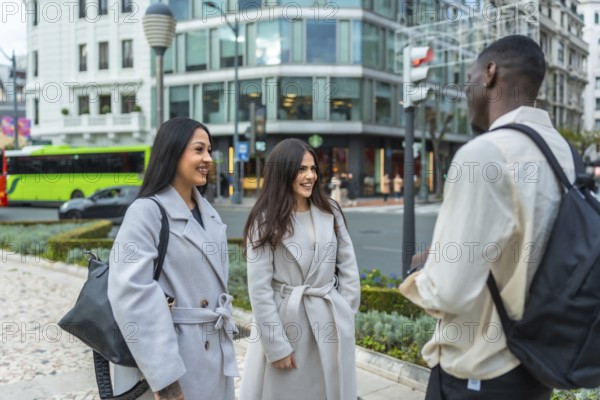 Young multiracial friends meeting on an urban street, engaging in a pleasant conversation,