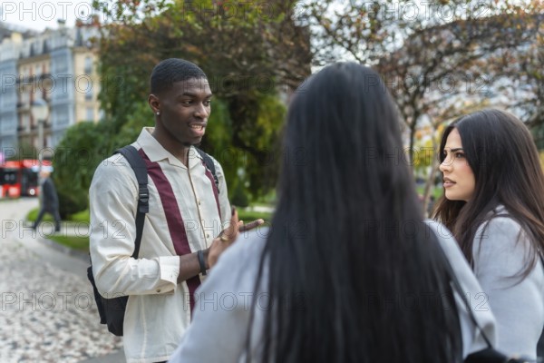 Young multiracial friends animatedly discussing ideas and stories on a city street, sharing