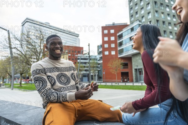 Group of diverse young adult friends laughing, smiling, and enjoying a casual urban leisure moment