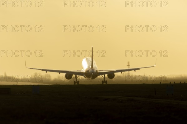 Boeing 777 commercial passenger airliner jet aircraft landing on a runway at sunset at London