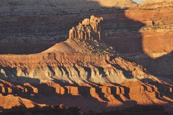 Rock formation in evening light with dramatic shadows in a barren desert landscape, Capitol Reef