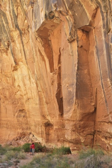 Impressive rock cliff with people below, showing the massive size and natural beauty, Capitol Reef