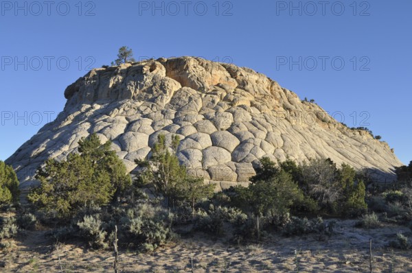 Spherical rock formation with sparse vegetation and clear sky, Capitol Reef National Park, Utha,