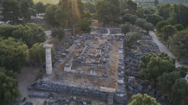 Temple of Zeus in backlight, architectural remains in a forest landscape with a visible stone