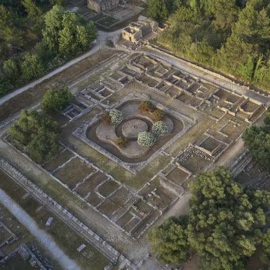 Leonidaion in morning light, symmetrical ancient ruins embedded in a green landscape, photographed