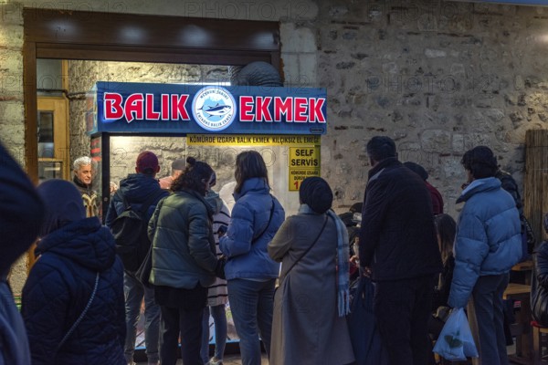 Istanbul, Turkey. January 3rd 2025. A queue of customers line up at a popular stall selling Balik