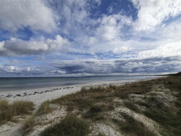 Quiet beach with grassy dunes under a wide, cloudy sky, Rügen, Baltic Sea