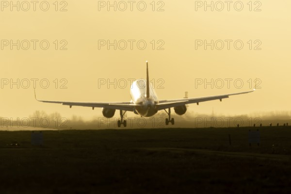 Boeing 777 commercial passenger airliner jet aircraft landing on a runway at sunset at London