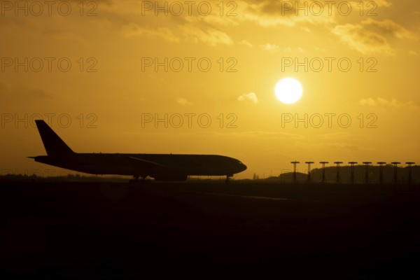 Boeing 777 A7-BFL commercial jet aircraft of Qatar cargo waiting to take off silhouette at sunset
