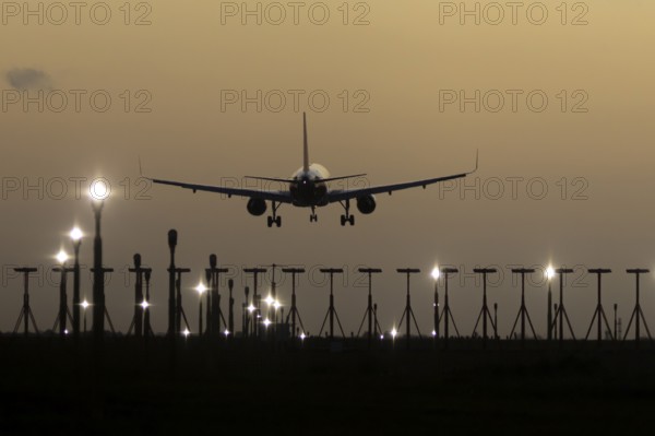 Airbus 320 commercial passenger airliner jet aircraft in flight on approach to land over runway