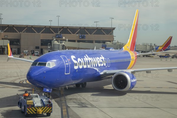 Phoenix, Arizona - A worker driving a tractor pushes a Southwest Airlines jet back from the gate as