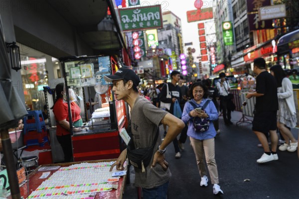 Bangkok, Thailand. February 18th 2025. A local man stops to buy lottery tickets along a busy