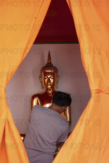 Bangkok, Thailand. March 25th 2025. A golden Buddha image covered in orange cloth in preparation