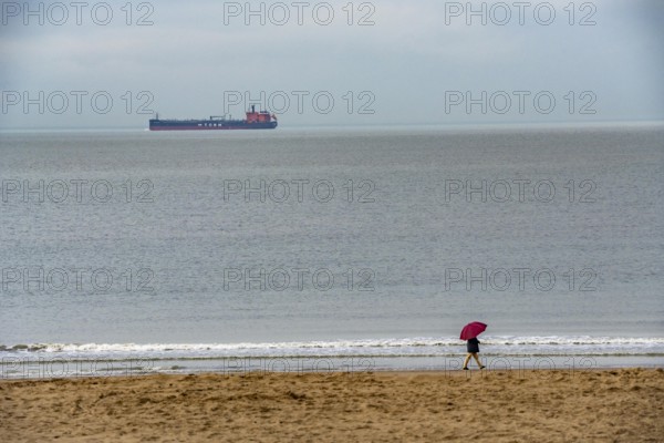 Winter break, on Zeedijk-Knokke, beach promenade in Knokke-Heist, beach walkers with umbrella when
