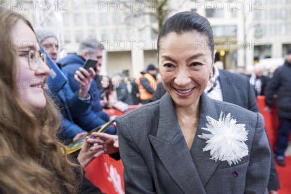 Michelle Yeoh has herself photographed with fans in front of the premiere of the film Everything