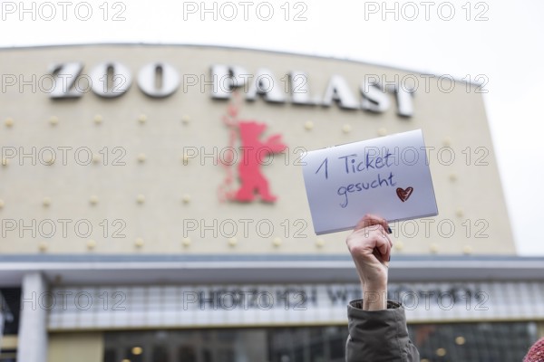 A visitor holds up a note with the inscription 1 ticket wanted for the film Everything Everywhere