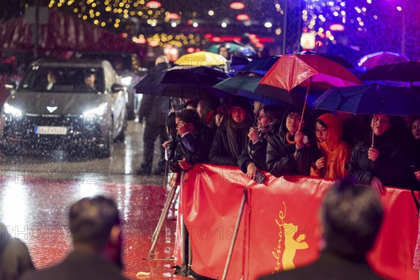 Fans in the rain with umbrellas at the opening of the Berlinale at the Theater am Potsdamer Platz
