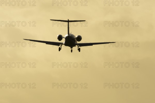 Cessna Citation small executive business jet aircraft in flight on approach to land at sunset at