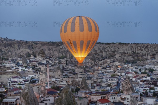 Goreme, Cappadocia. Turkey. October 14th 2018. A hot air balloon flies over the Anatolian village