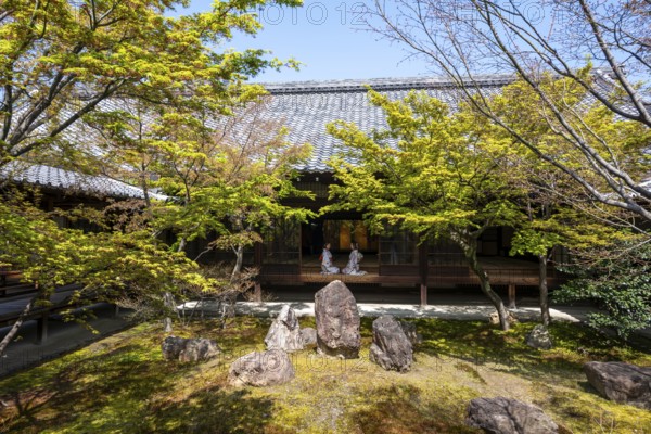Two Japanese woman dressed in kimono sitting at an open door, courtyard of O-shoin with Shione