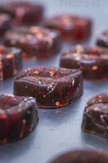 Close-up of a reddish shimmering chocolate with a smooth surface, vegan chocolates production,
