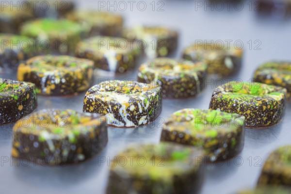 Series of decorated chocolates with artistic colorful patterns, vegan chocolates production,