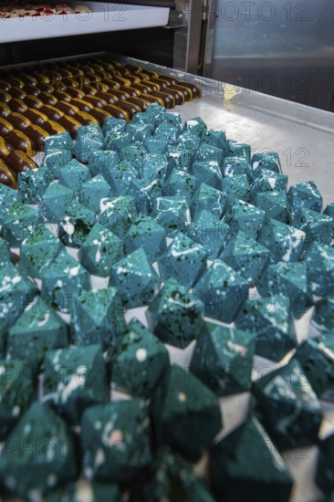 Blue prismatic chocolates with shiny surface in a bakery, Easter production of regional products,