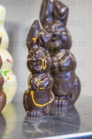 Close-up of a dark-colored chocolate bunny with decoration, Easter production of regional products,