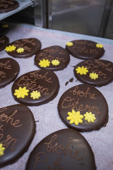 Chocolate Easter eggs decorated with yellow flowers, served on a tray, Easter production of