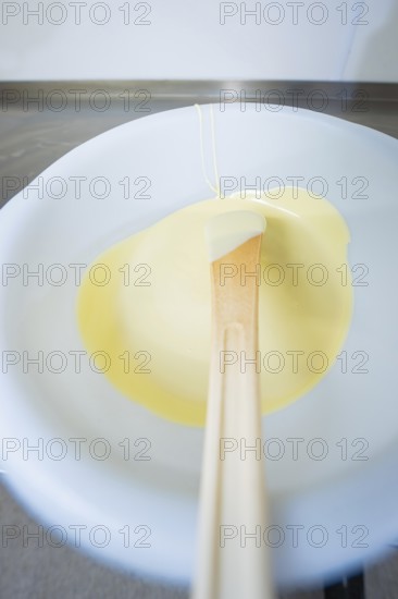 White chocolate on a spoon in liquid state, Easter production of regional products, Haselstaller