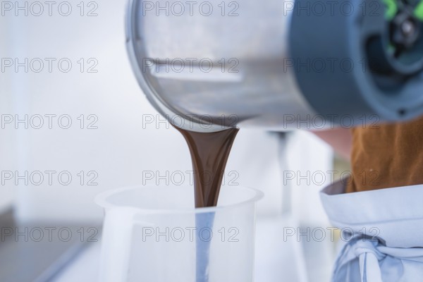 Liquid chocolate is poured from a mixer, Vegan Tarts Production, Haselstaller Hof, Gechingen,