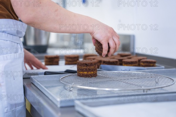 Person places cookies on a grid in the kitchen, vegan cake production, Haselstaller Hof, Gechingen,