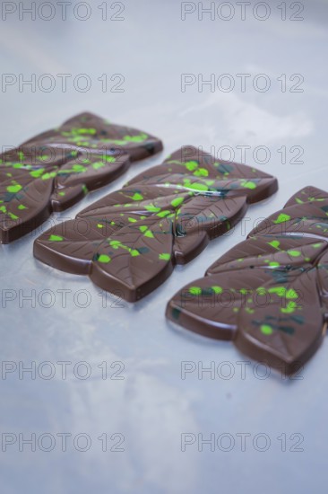 Dark chocolate bars with green dots and lines on a table, vegan chocolate production, Haselstaller