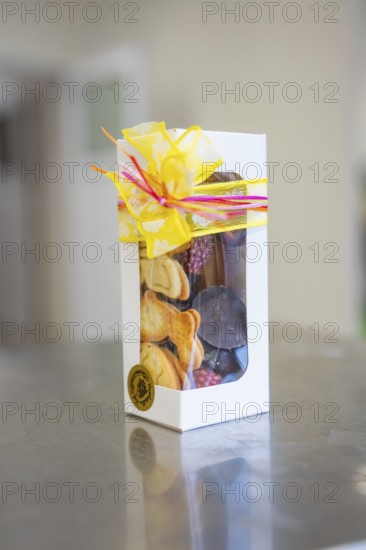 Elegant gift box decorated with chocolates and a yellow bow, Easter production of regional