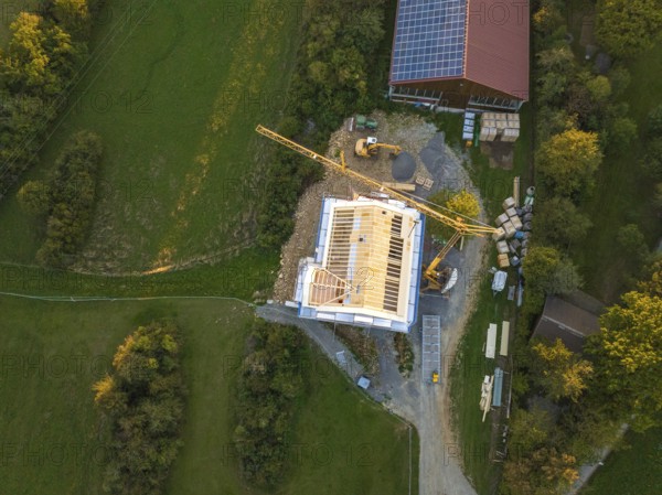 Aerial view of a construction site with a large construction building and solar system next door,