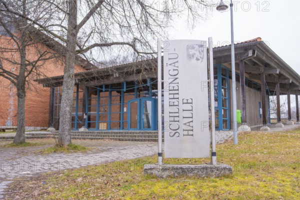 Schlehengäu Halle building with sign in front of it, surrounded by trees, winter atmosphere,