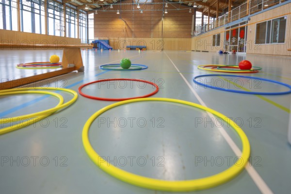 Various tires and balls on the floor of a light-flooded gym, Schlehengäu Sporthalle Gechingen, Calw