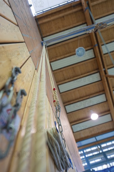 Climbing rope attached to a sports hall with wooden walls and neon lights, Schlehengäu Sporthalle