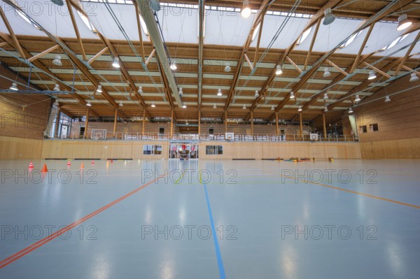 Empty sports hall with floor lines, wooden structure and several basketball hoops, Schlehengäu