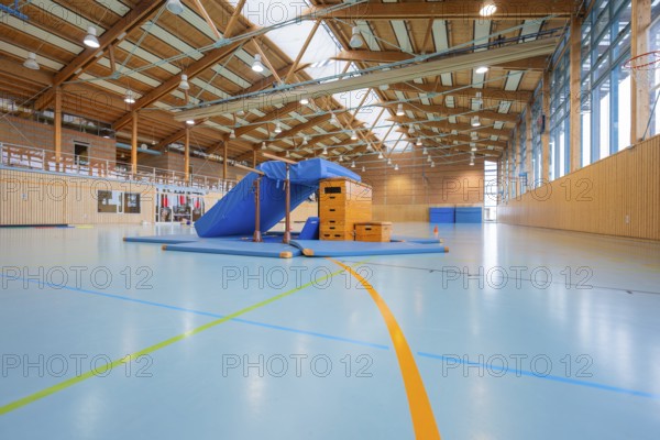 Empty sports hall with equipment available and a window front that illuminates the room,