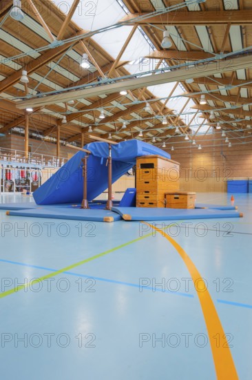 Gymnastic equipment and mats in the wooden sports hall, bright and spacious atmosphere, Schlehengäu