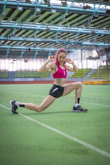 Woman stretching on green field, demonstrating flexibility and athletic energy, middle distance