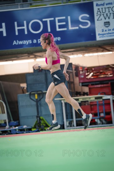 Female athlete dynamically running sideways through the interior of a hall, middle distance runner
