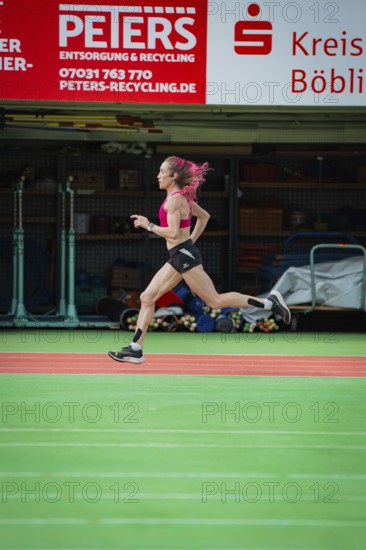 Female athlete sprints quickly through a hall, the movements are dynamic, middle distance runner